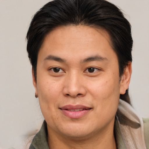 Joyful asian adult male with short  brown hair and brown eyes