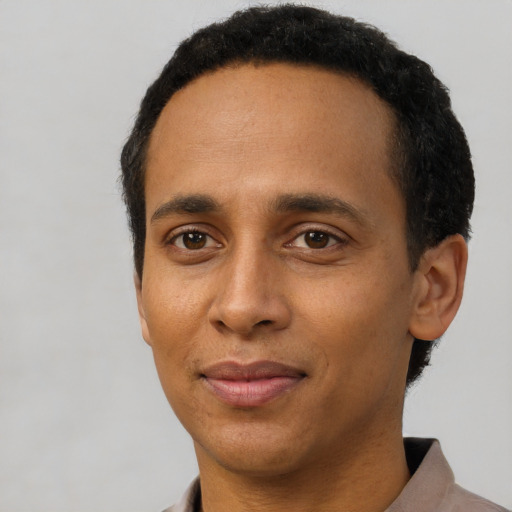 Joyful black young-adult male with short  black hair and brown eyes