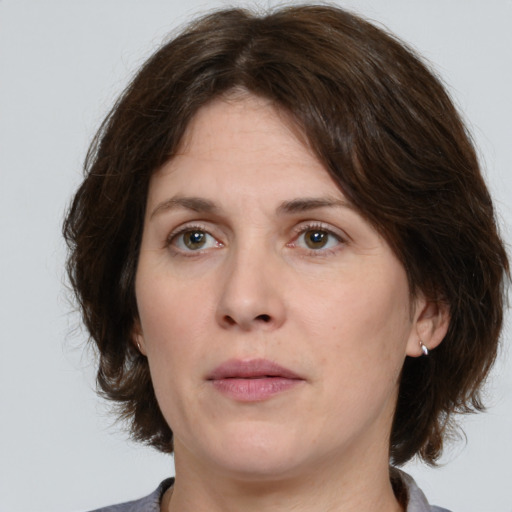 Joyful white young-adult female with medium  brown hair and green eyes