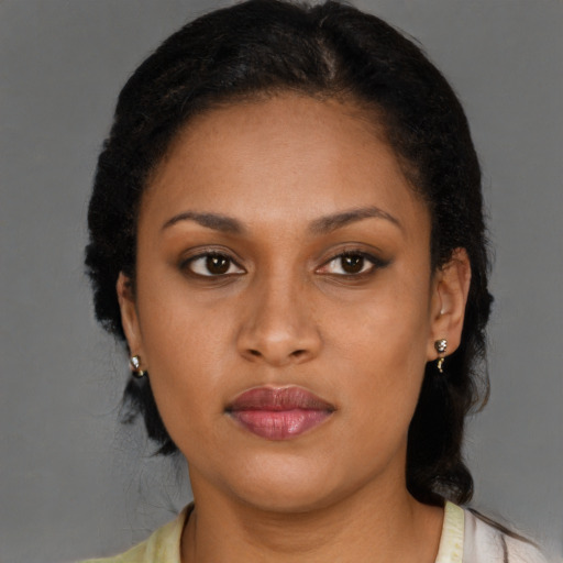 Joyful black young-adult female with long  brown hair and brown eyes