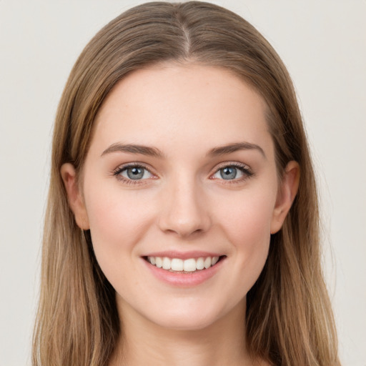 Joyful white young-adult female with long  brown hair and grey eyes