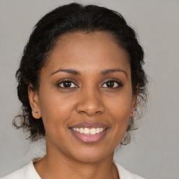 Joyful latino young-adult female with medium  brown hair and brown eyes