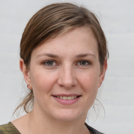 Joyful white young-adult female with medium  brown hair and grey eyes