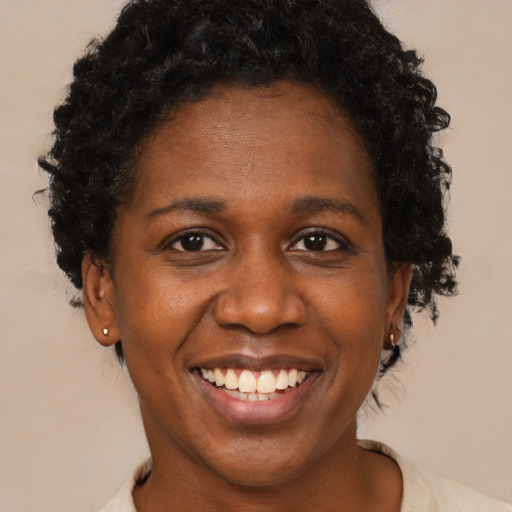 Joyful black adult female with short  brown hair and brown eyes