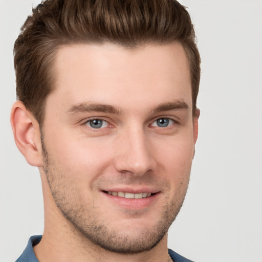 Joyful white young-adult male with short  brown hair and grey eyes