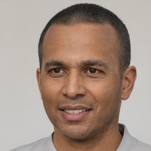 Joyful latino adult male with short  brown hair and brown eyes