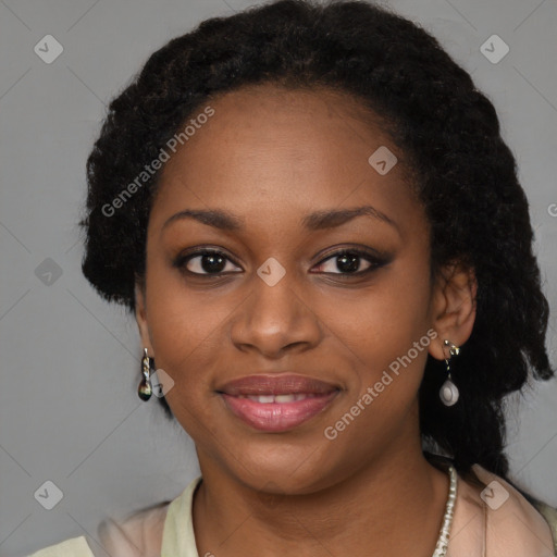 Joyful black young-adult female with long  black hair and brown eyes