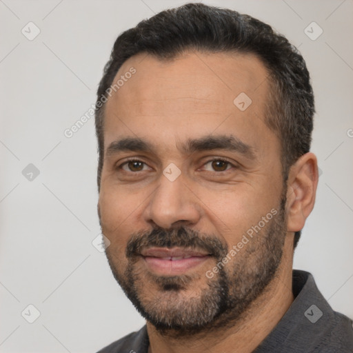 Joyful white adult male with short  black hair and brown eyes