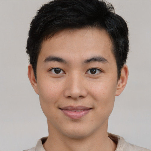 Joyful asian young-adult male with short  brown hair and brown eyes