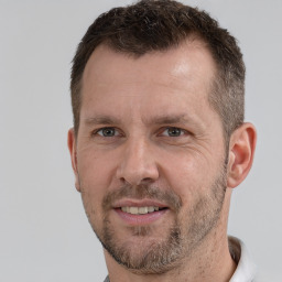 Joyful white adult male with short  brown hair and grey eyes