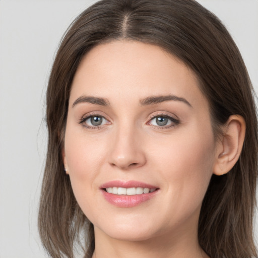 Joyful white young-adult female with long  brown hair and grey eyes