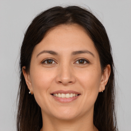 Joyful white young-adult female with long  brown hair and brown eyes