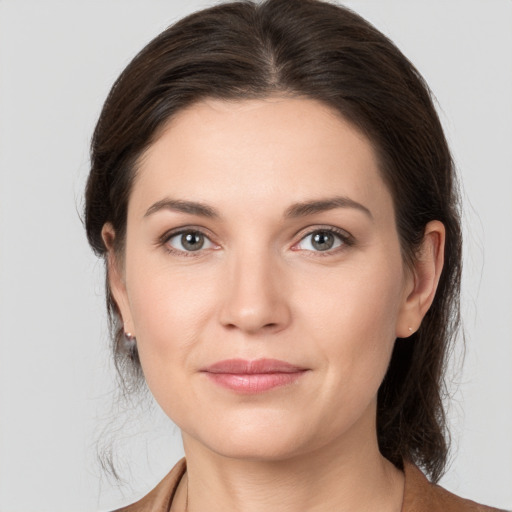 Joyful white young-adult female with medium  brown hair and grey eyes