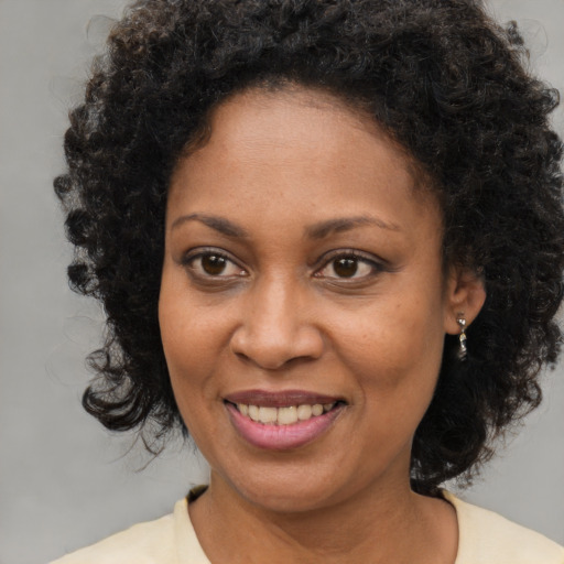 Joyful black young-adult female with medium  brown hair and brown eyes