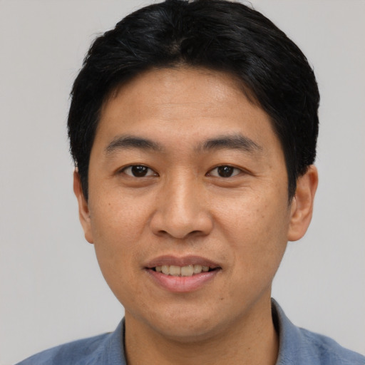 Joyful asian young-adult male with short  black hair and brown eyes
