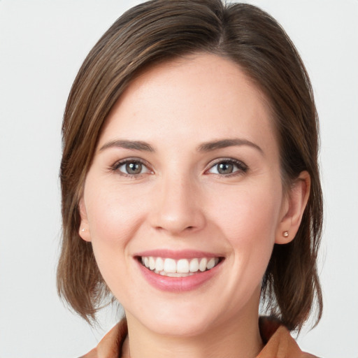 Joyful white young-adult female with medium  brown hair and grey eyes