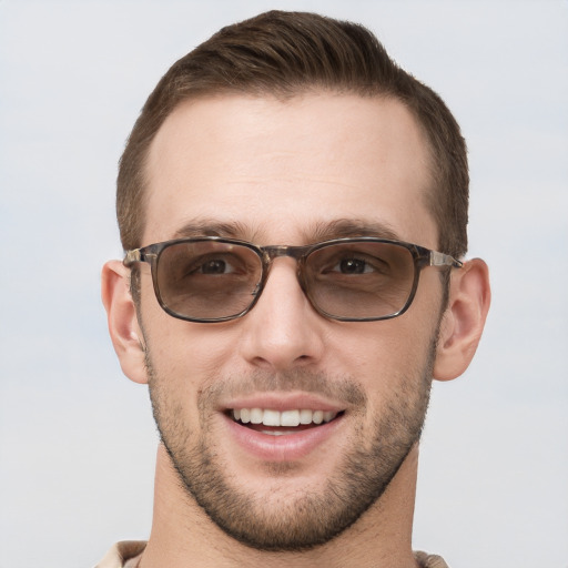 Joyful white young-adult male with short  brown hair and grey eyes