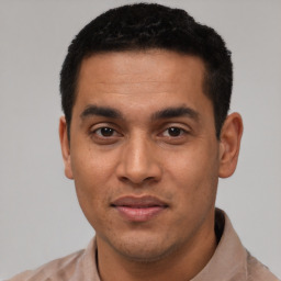 Joyful latino young-adult male with short  black hair and brown eyes