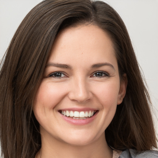 Joyful white young-adult female with long  brown hair and brown eyes