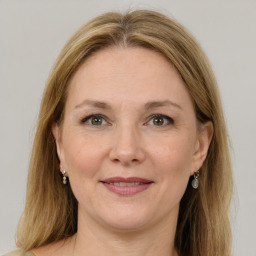 Joyful white adult female with medium  brown hair and grey eyes