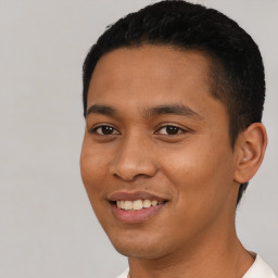 Joyful latino young-adult male with short  black hair and brown eyes