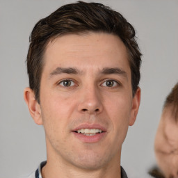 Joyful white young-adult male with short  brown hair and brown eyes