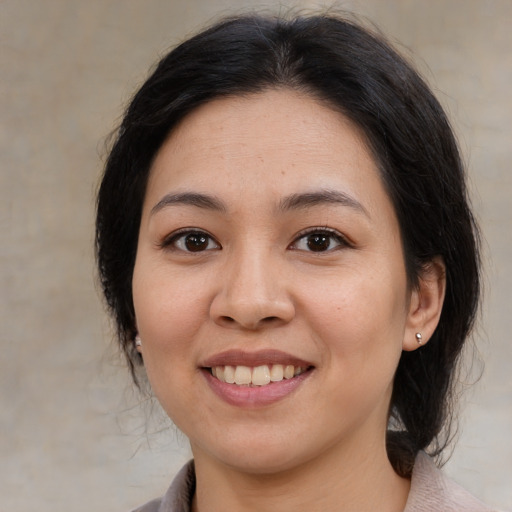 Joyful latino young-adult female with medium  brown hair and brown eyes
