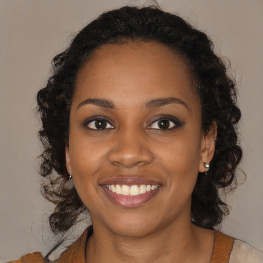 Joyful black young-adult female with medium  brown hair and brown eyes