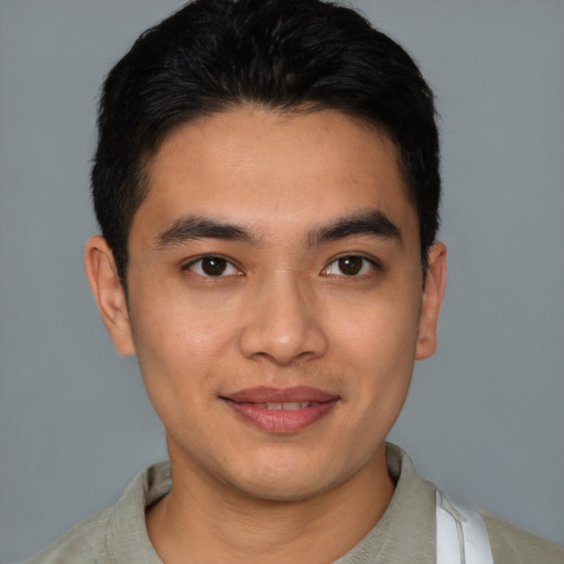 Joyful latino young-adult male with short  brown hair and brown eyes