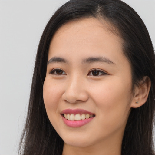 Joyful asian young-adult female with long  brown hair and brown eyes
