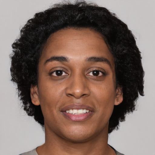 Joyful black young-adult female with short  black hair and brown eyes