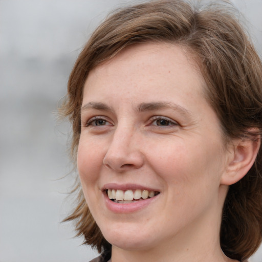 Joyful white young-adult female with medium  brown hair and grey eyes