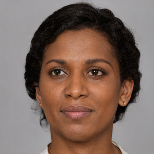 Joyful black adult female with short  brown hair and brown eyes