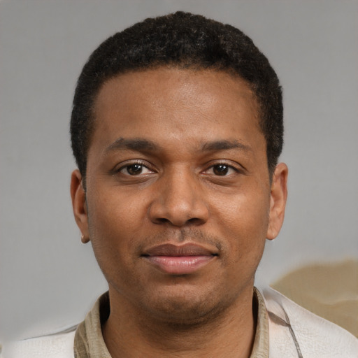 Joyful black young-adult male with short  brown hair and brown eyes
