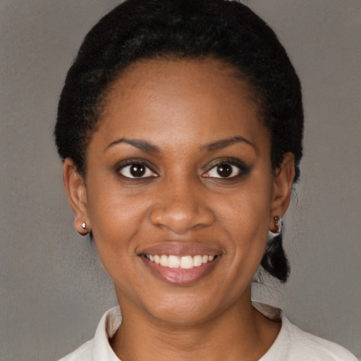 Joyful black young-adult female with short  black hair and brown eyes