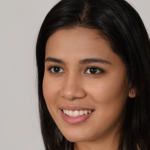 Joyful latino young-adult female with long  brown hair and brown eyes