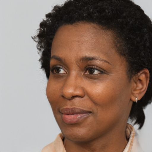 Joyful black adult female with short  black hair and brown eyes
