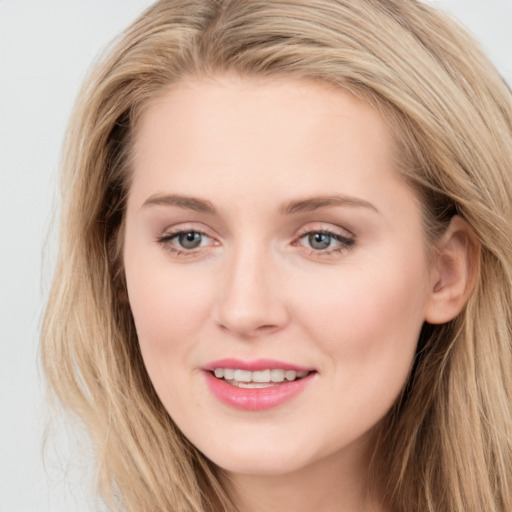 Joyful white young-adult female with long  brown hair and blue eyes