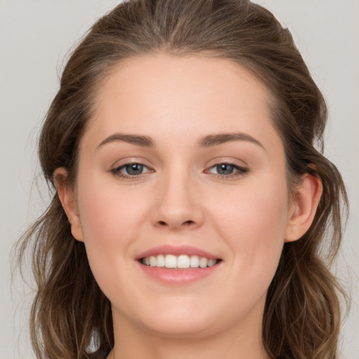 Joyful white young-adult female with long  brown hair and grey eyes