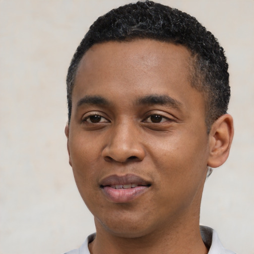 Joyful black young-adult male with short  black hair and brown eyes