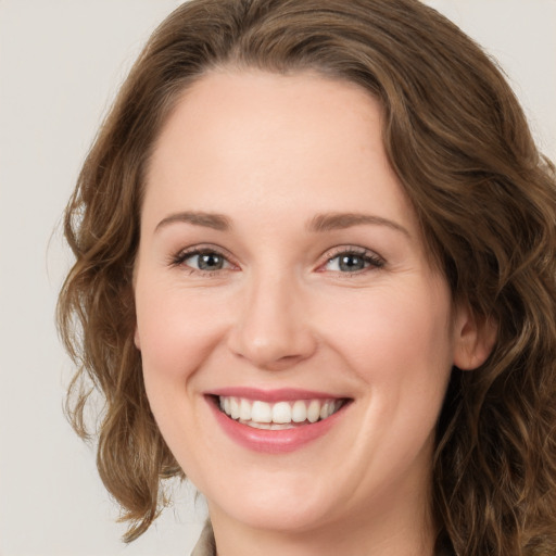 Joyful white young-adult female with medium  brown hair and green eyes