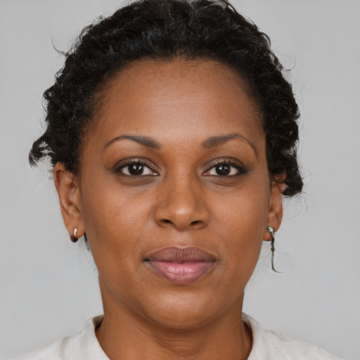 Joyful black adult female with short  brown hair and brown eyes