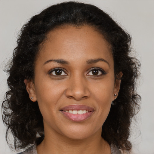 Joyful black young-adult female with medium  brown hair and brown eyes
