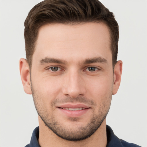 Joyful white young-adult male with short  brown hair and grey eyes