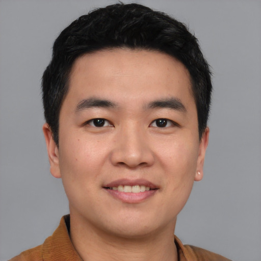 Joyful asian young-adult male with short  black hair and brown eyes