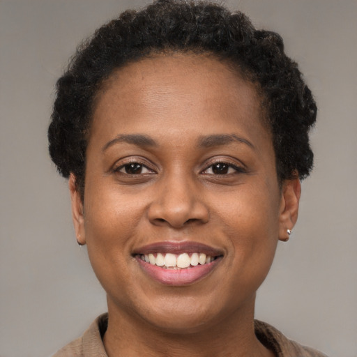 Joyful black young-adult female with short  brown hair and brown eyes
