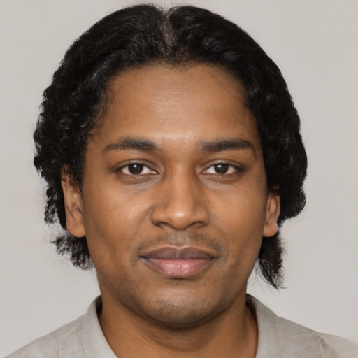 Joyful black young-adult male with short  black hair and brown eyes