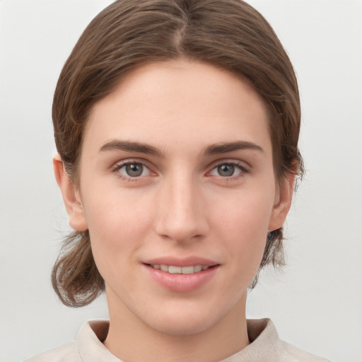 Joyful white young-adult female with medium  brown hair and grey eyes