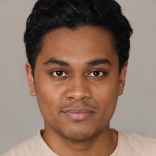 Joyful black young-adult male with short  black hair and brown eyes