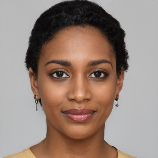 Joyful black young-adult female with short  black hair and brown eyes